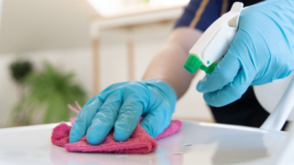 Mulher limpando balcão.