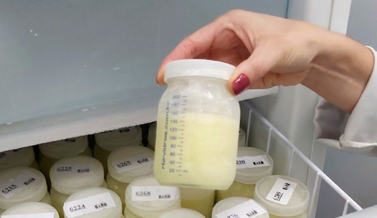 Mão segurando frasco de leite