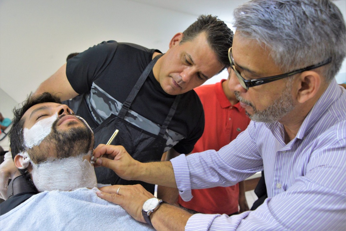 homem cortando a barba de um cliente