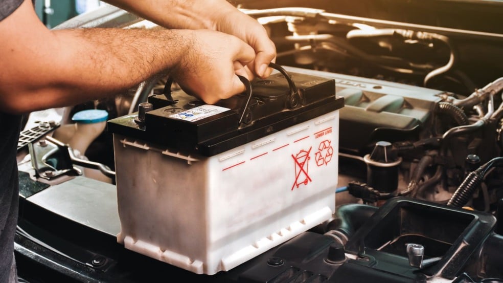 Mecânico realizando a troca de bateria.