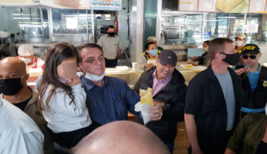 Foto de Jair Bolsonaro carregando criança em lanchonete