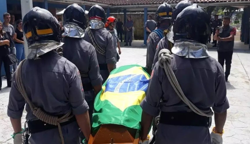 Foto de caixão sendo levado por soldados da polícia militar