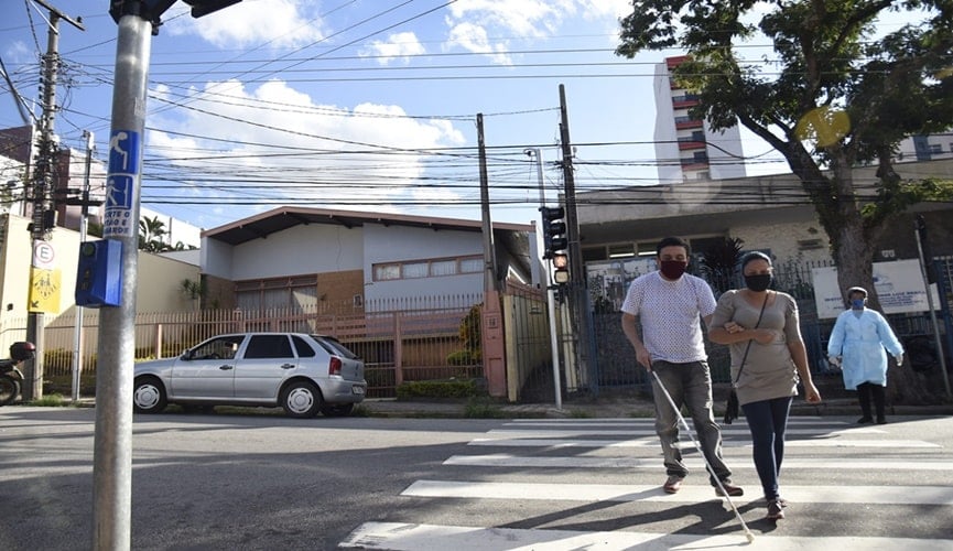 Foto de deficiente visual atravessando a rua