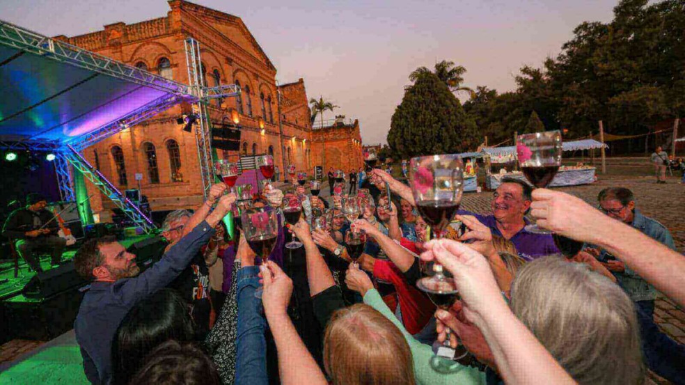 Pessoas no Espaço Expressa de Jundiaí brindando com taças de vinho