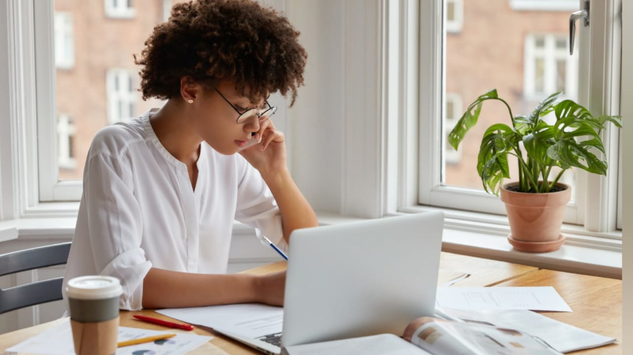 Mulher com notebook falando no telefone