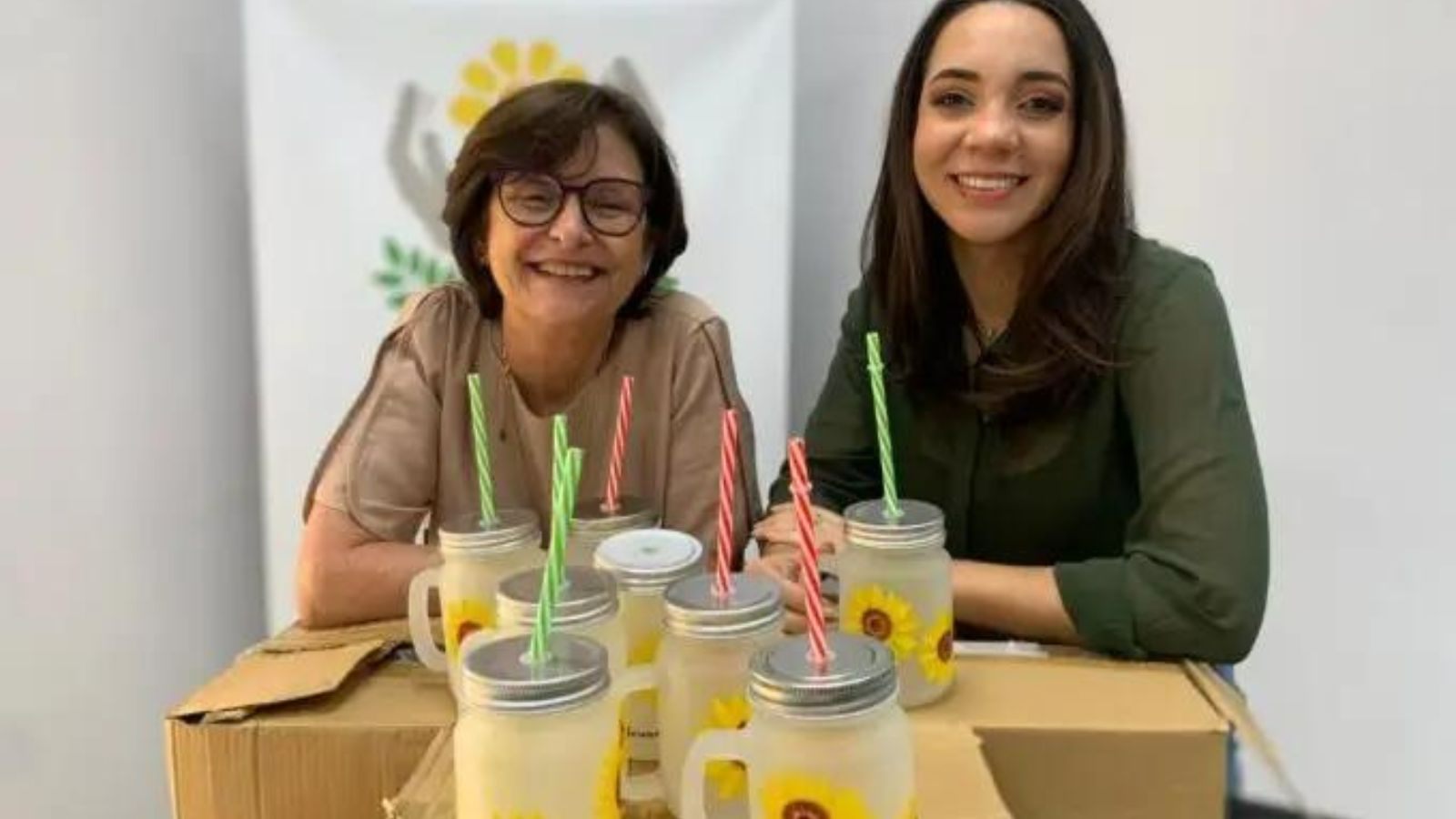Mulheres posam com as canecas girassol na APAE Jundiaí.