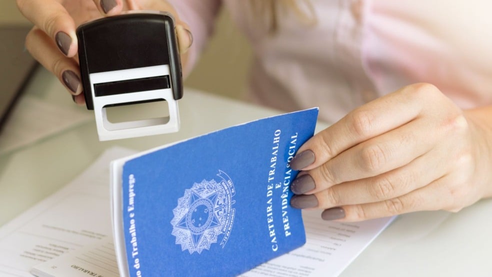 Carteira de trabalho sendo assinada.