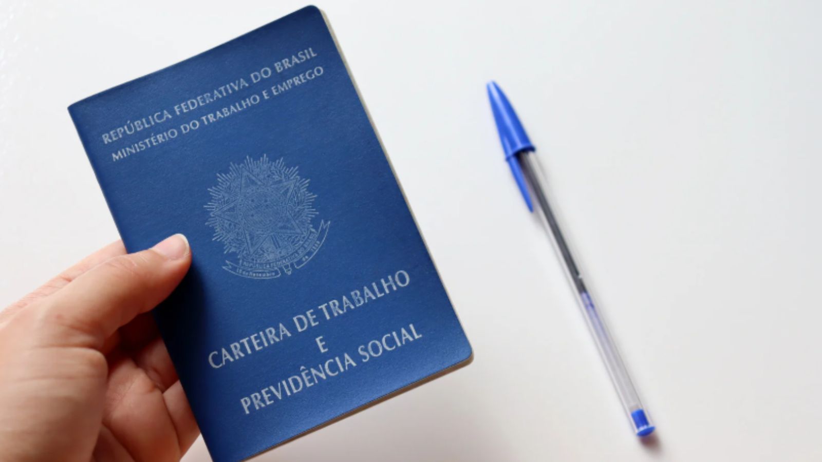 Carteira de trabalho e caneta bic.
