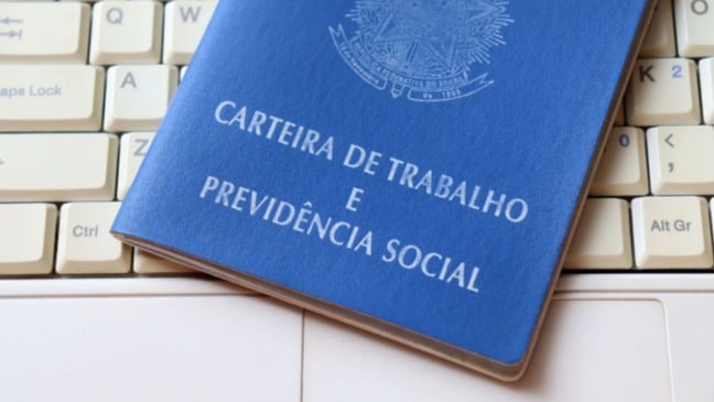 Carteira de trabalho sobre computador.