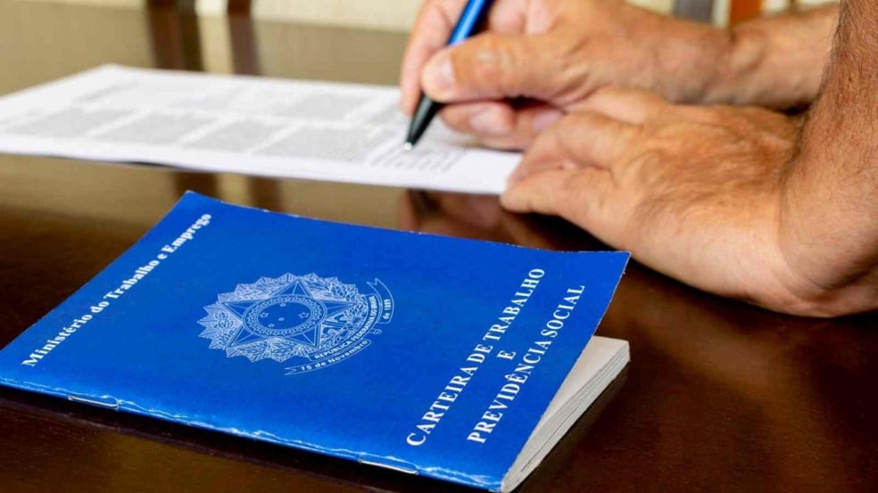 Assinatura em carteira de trabalho.
