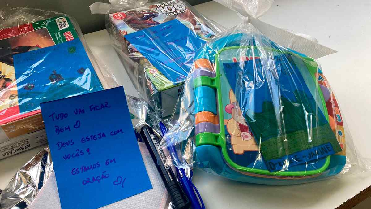 Presentes embrulhados com mensagens de apoio para crianças, incluindo quebra-cabeças e brinquedos, destinados a doações.