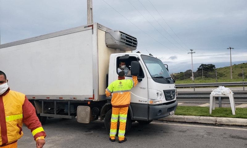 Funcionário da CCR atende caminhoneiro na beira de estrada