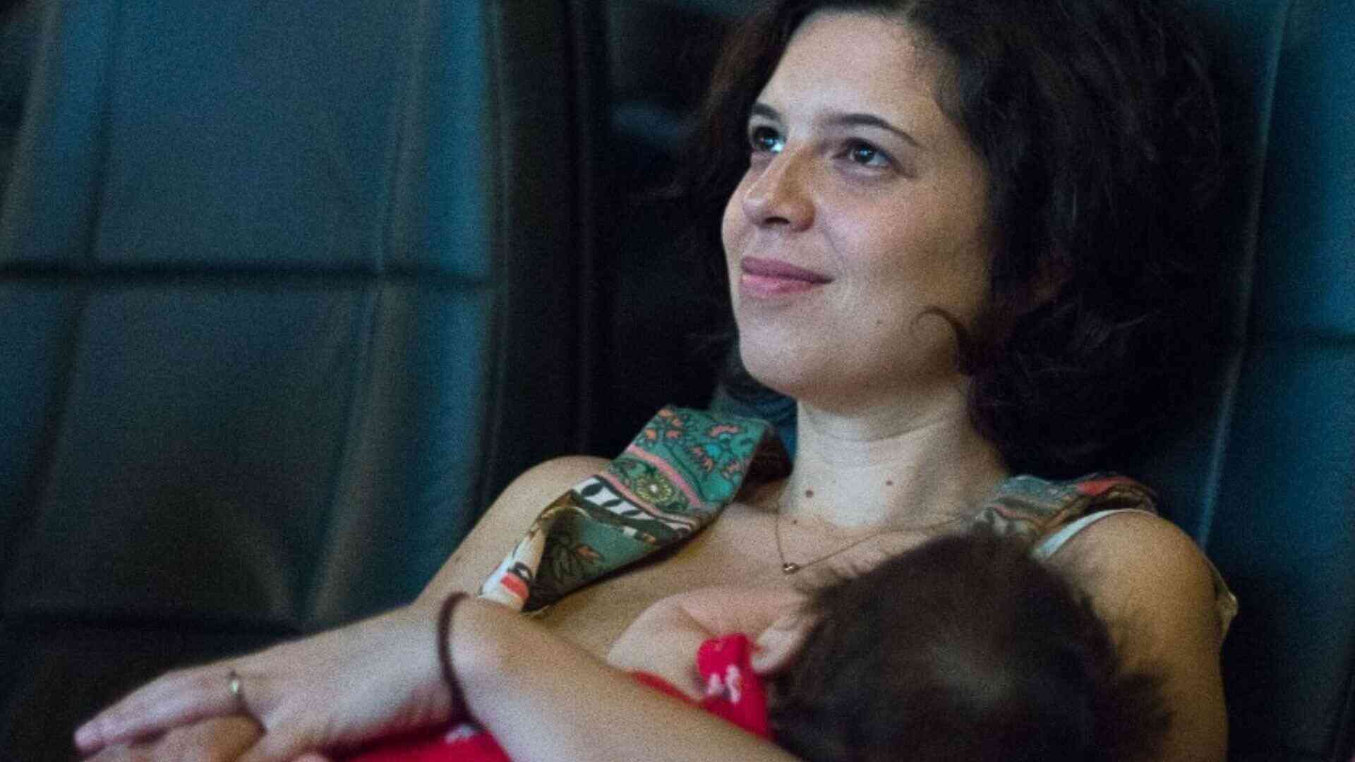Mãe com bebê no colo no cinema