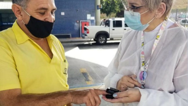 Profissional da saúde afere temperatura de cidadão em terminal de Jundiaí