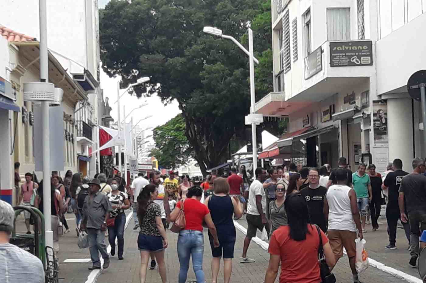 Rua movimentada no centro de Jundiaí com pessoas caminhando e prédios comerciais.