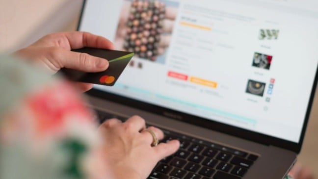 Mulher cadastrando cartão em site.