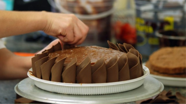 Bolo sendo confeitado.