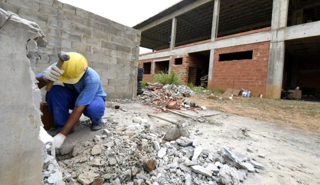 Pedreiro quebrando muro