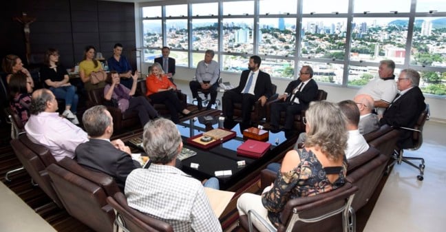 mesa de reunião com diversas pessoas