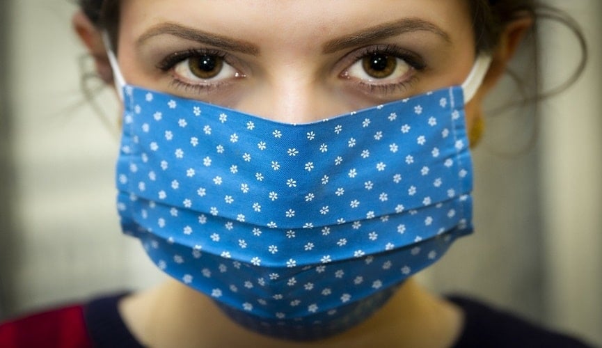 Foto de rosto feminino com máscara azul caseira