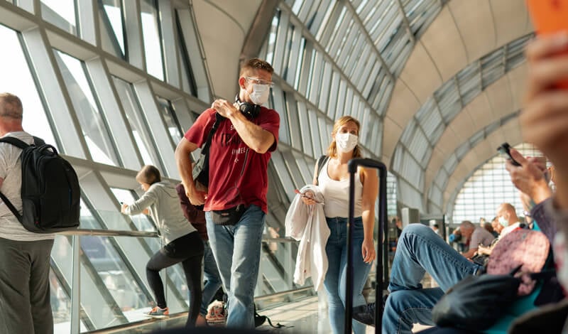 Pessoas em aeroporto usam máscaras