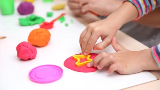 Criança modelando massinha.