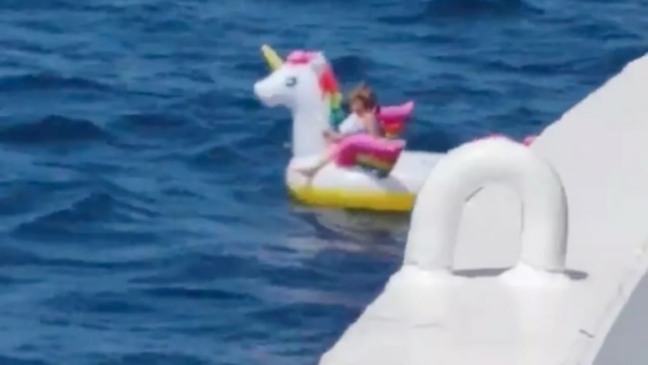 Menina flutuando na boia de unicórnio antes de ser resgatada.