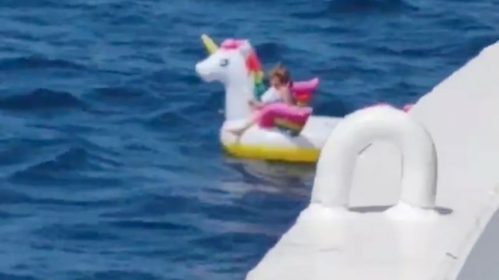 Menina flutuando na boia de unicórnio antes de ser resgatada.