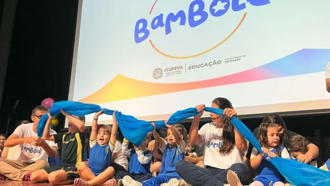 Crianças participam de uma atividade com um tecido azul no projeto Bambolê, em Itupeva.