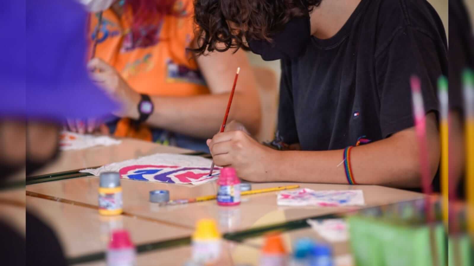uma mão pintando colorido em uma papel