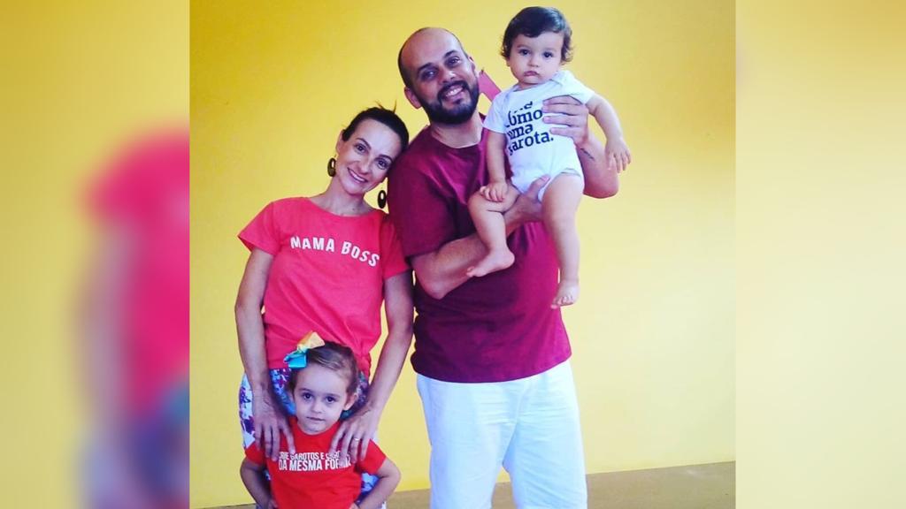 mulher ao lado de homem segurando uma crianças