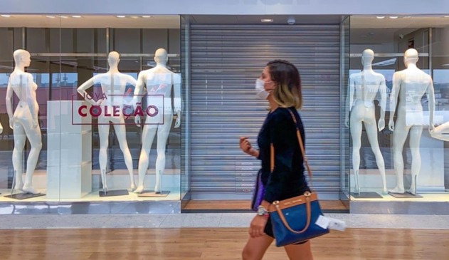 Mulher andando em frente à loja fechada