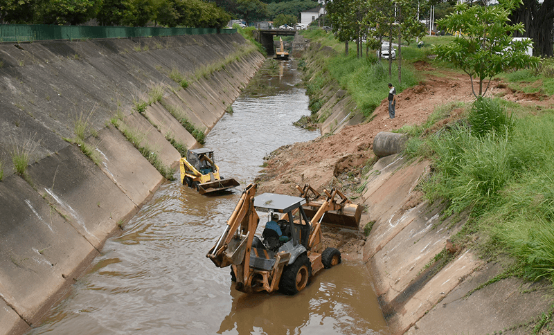 Tratores trabalhando dentro de córregos e rios