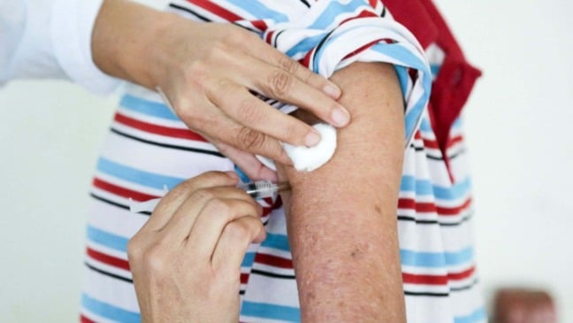 Idoso recebendo dose de vacina.