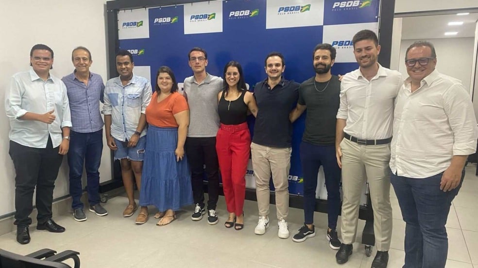 Membros do PSDB Jovem em frente à painél.