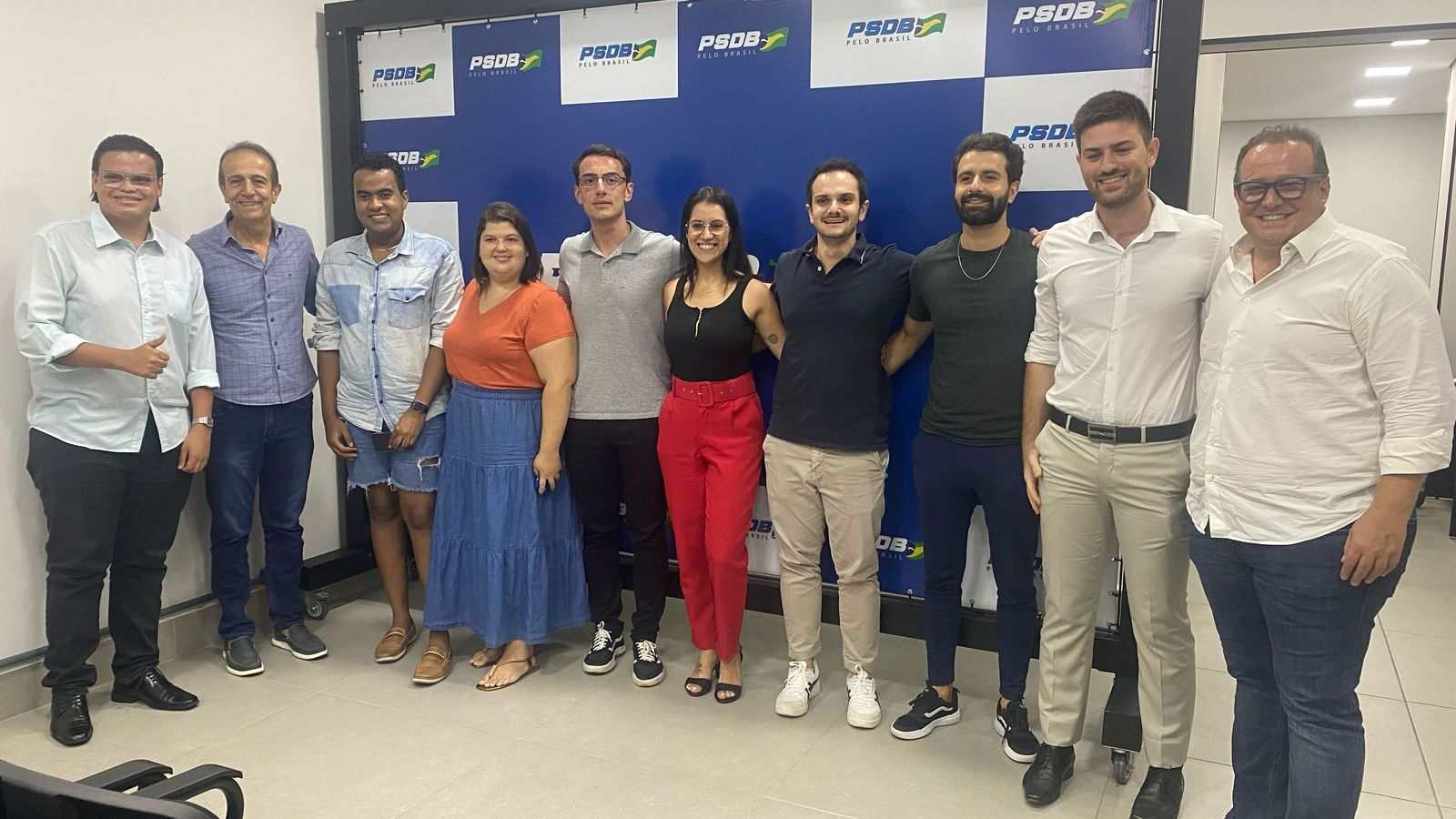 Membros do PSDB Jovem em frente à painél.