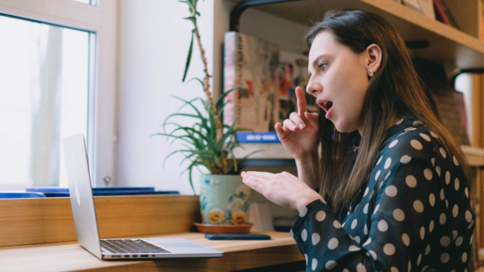 Mulher praticando Libras em frente ao computador.