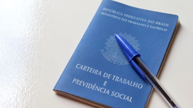 carteira de trabalho com caneta azul.