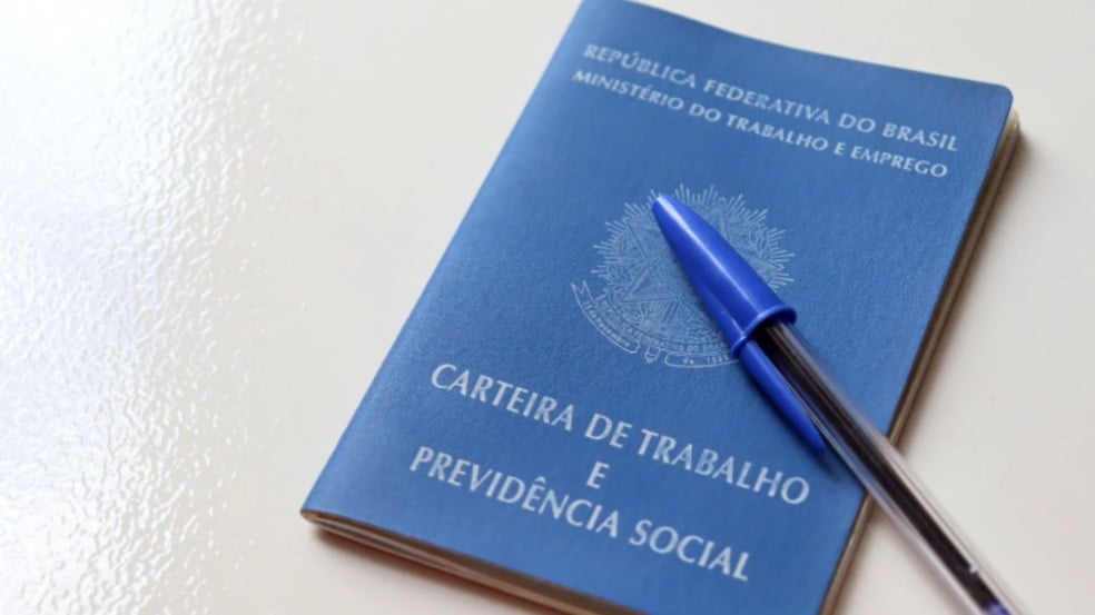 carteira de trabalho com caneta azul.