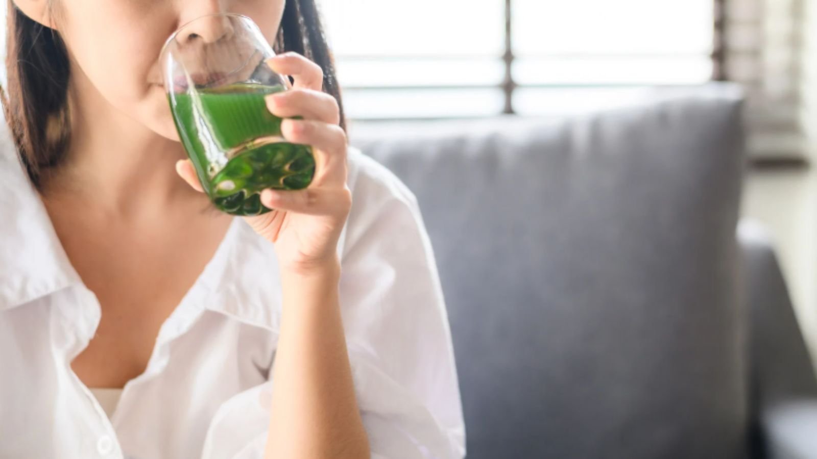 Mulher bebendo suco verde detox.