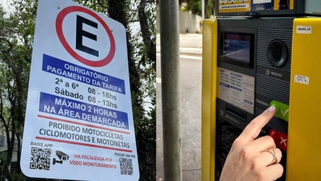 À esquerda, placa de estacionamento; à direita máquina de pagamento de estacionamento rotativo.