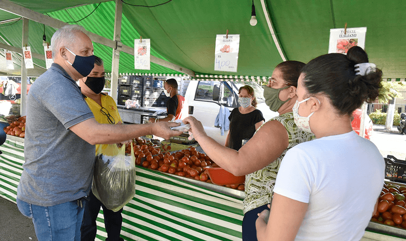 Funcionários entregam máscaras a consumidores
