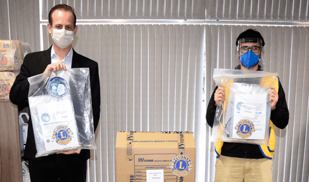 Tiago Texera e representante da Lions Club com materiais doados