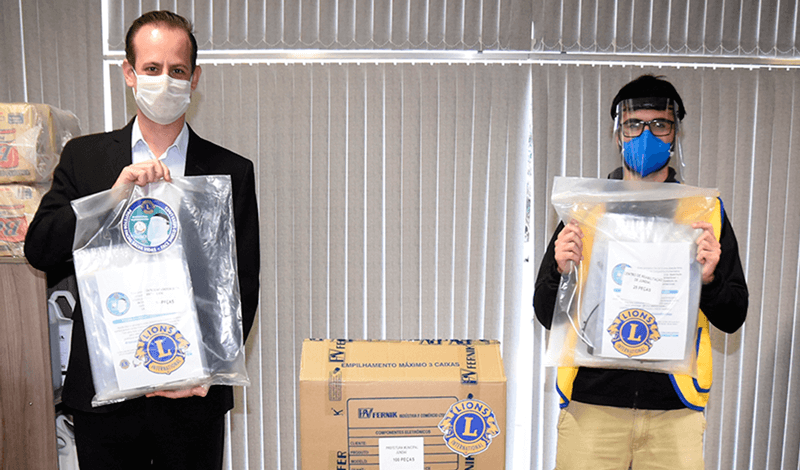 Tiago Texera e representante da Lions Club com materiais doados