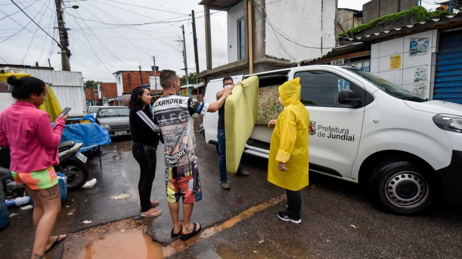 Pessoas tirando colchão de dentro de carro