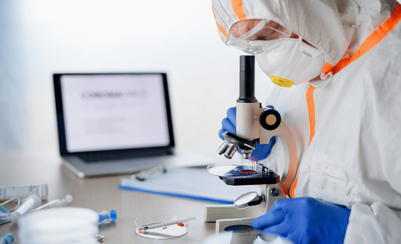 Trabalhador analisa amostras com microscópio