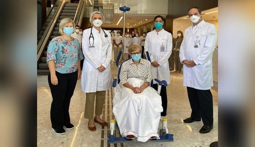 Foto de idosa com equipe médica