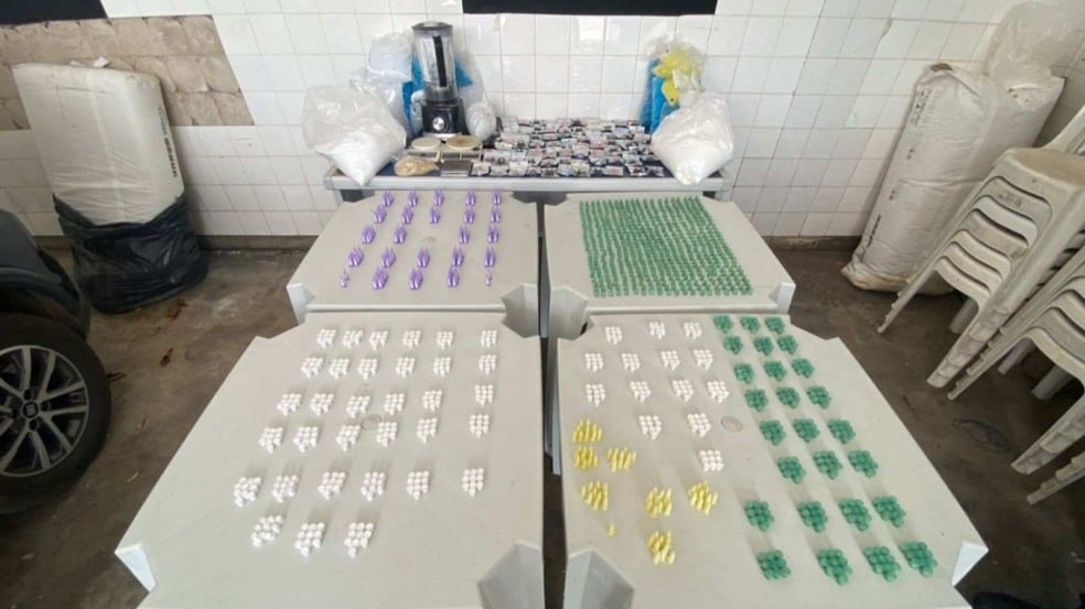 Mesa com dezenas de porções de drogas embaladas, balanças de precisão, sacos com pó branco e utensílios usados no preparo, apreendidos em operação da GM e PM em Itatiba.