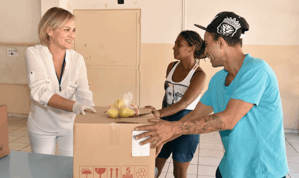 Família retira cesta com alimentos na escola
