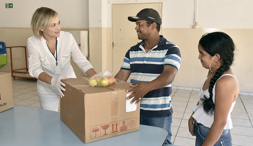 Foto de mulher entregando cesta a homem